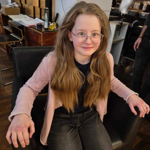 2025-6 Ein Kind mit langen Haaren lächelt in die Kamera